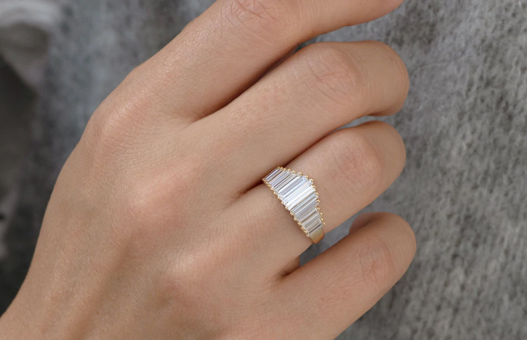 Women's hand wearing a white diamond baguette ring.