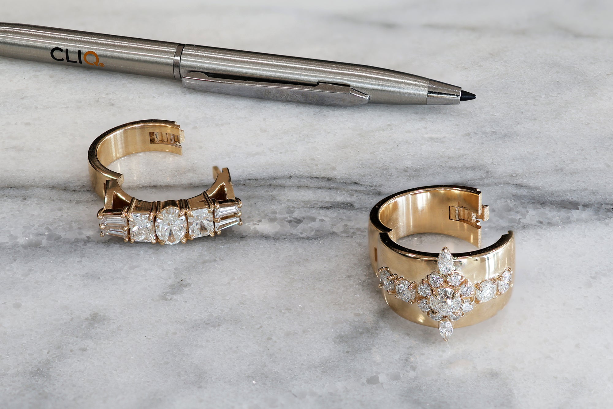 Two wide golden rings with white diamonds that open up with a hinge.